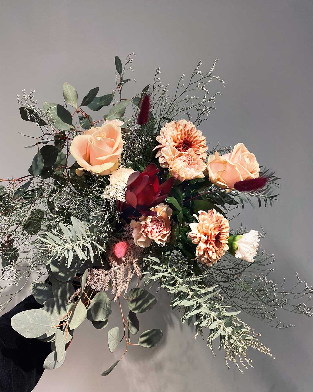 Blombud innehållandes krysantemum och rosor och nejlikor